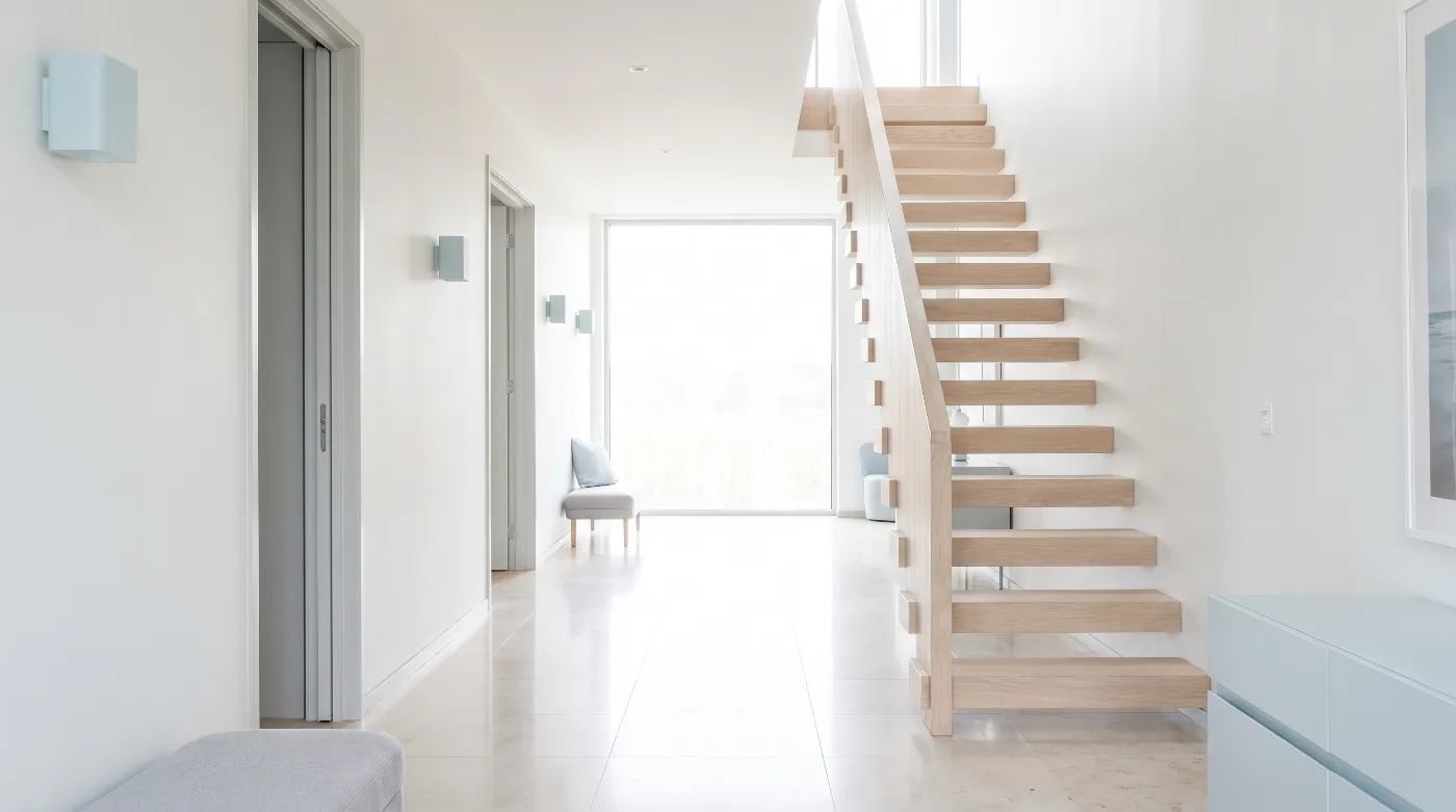 Bright hallway with a pale oak staircase and a tall window