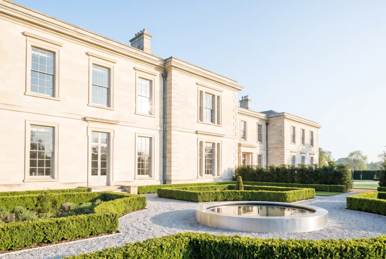 Country house seen across a formal garden in morning light