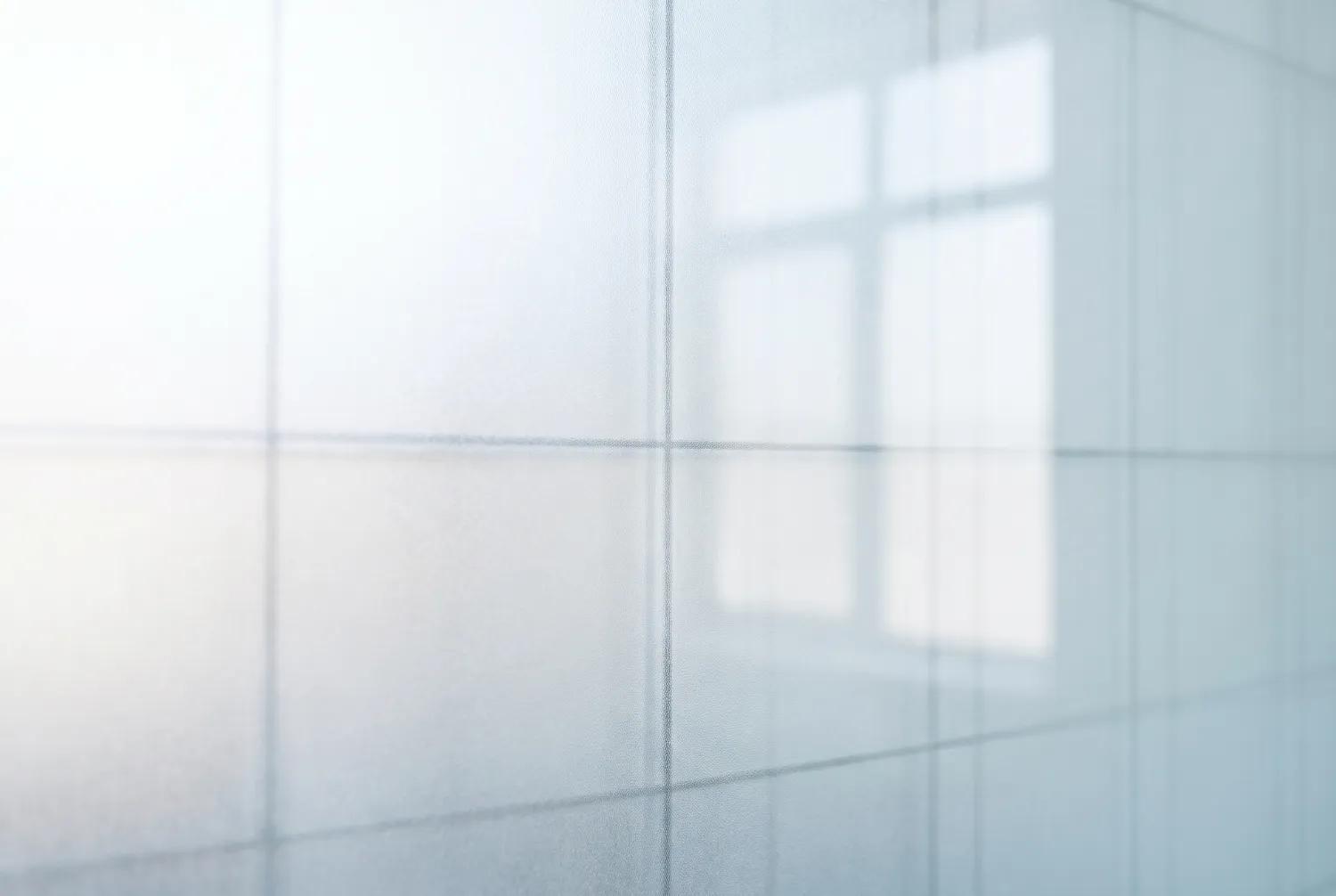 Out-of-focus pale grid on a matte glass surface with a window reflection