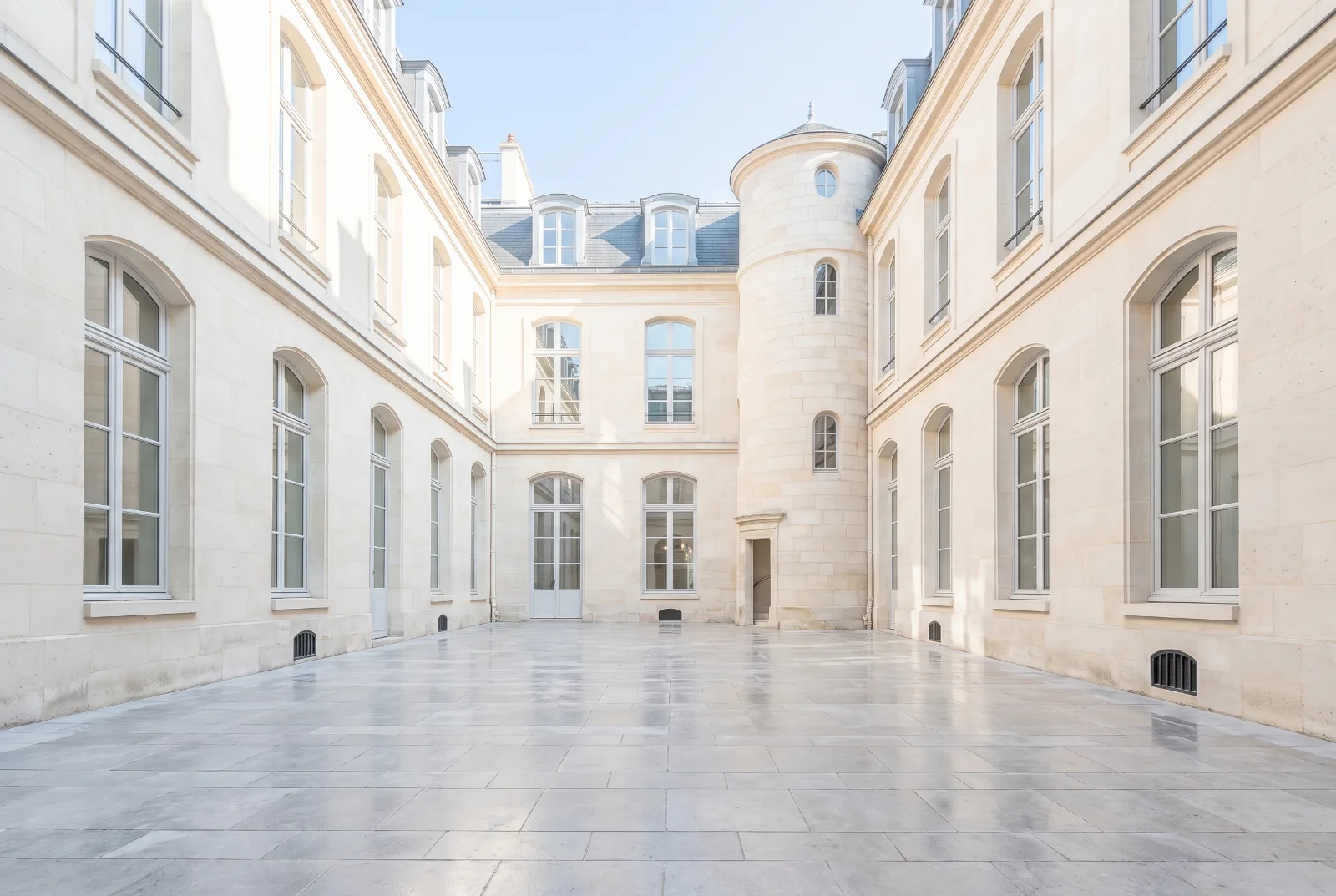 Paris courtyard in clear morning light with a stone stair tower