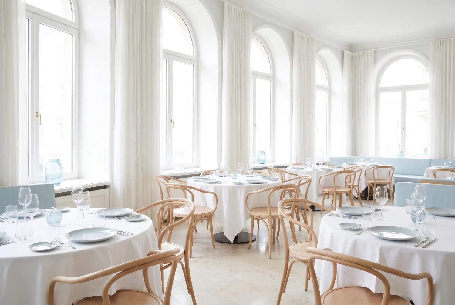 Restaurant interior before service with set tables and bentwood chairs
